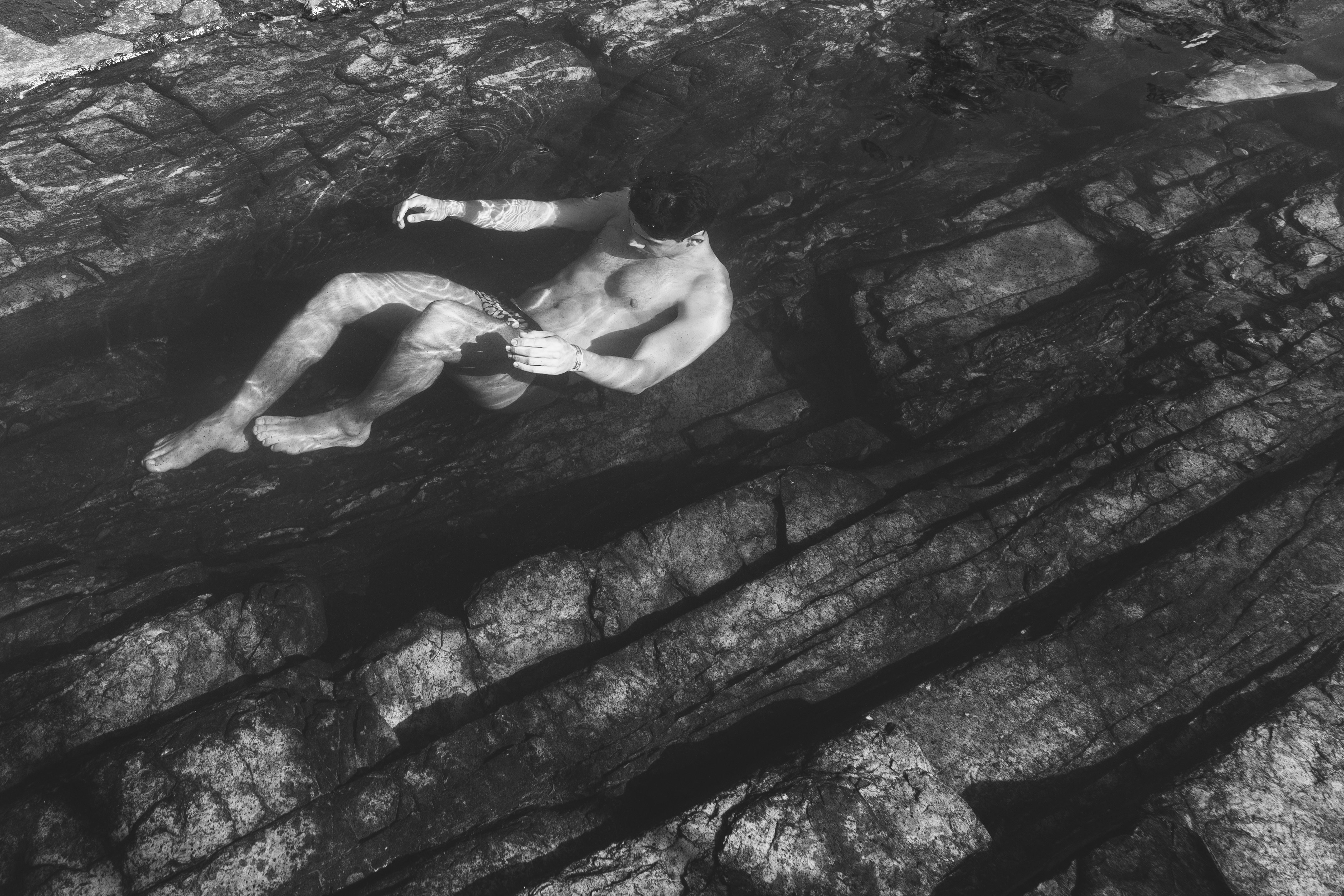 grayscale photo of man in water